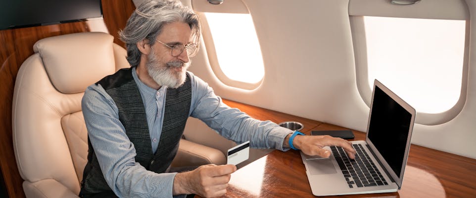 senior man using laptop on plane