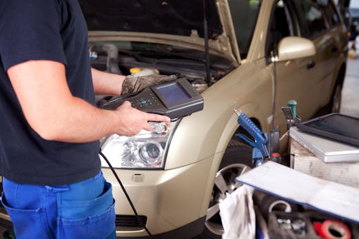Transmission Diagnostic Service - Richmond VA A man diagnosing what's wrong with a car using computer diagnostic technology.