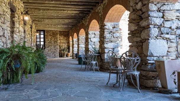 Peoples Choice Plumbing San Antonio TX |picture of a quaint stone esplande with shady patio tables