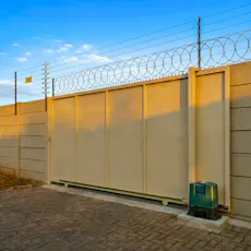 Precast wall that has an electric fence and razor wire plus a gate and gate motor