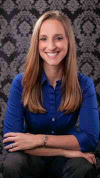 Dr. Shari guiding a knee exercise with a runner using a ball against wall