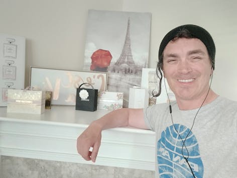 Justin McMillen, founder of Digital Dove Media, smiling in a casual selfie with a beanie and sunglasses atop his head, standing in a creative, faith-inspired workspace.