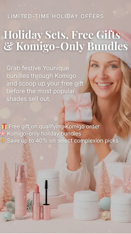 Smiling woman in pink Santa hat holding a gift box with Younique Komigo holiday makeup displayed in front.