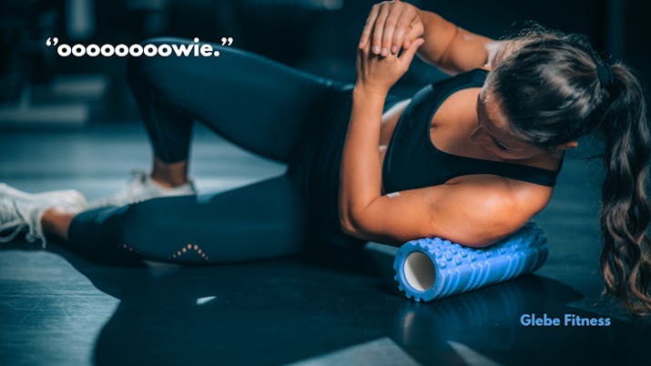 fit woman foam rolling her lats