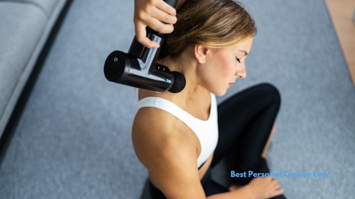 woman massaging her neck with a massage gun.