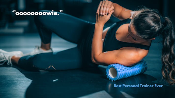 fit woman foam rolling lats in the gym