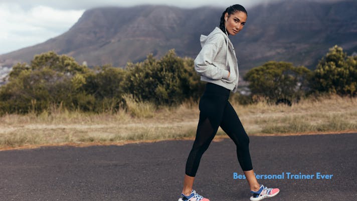 woman talking a long walk outdoors with headphones in.